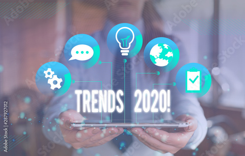 Writing note showing Trends 2020. Business concept for general direction in which something is developing or changing Female human wear formal work suit presenting smart device