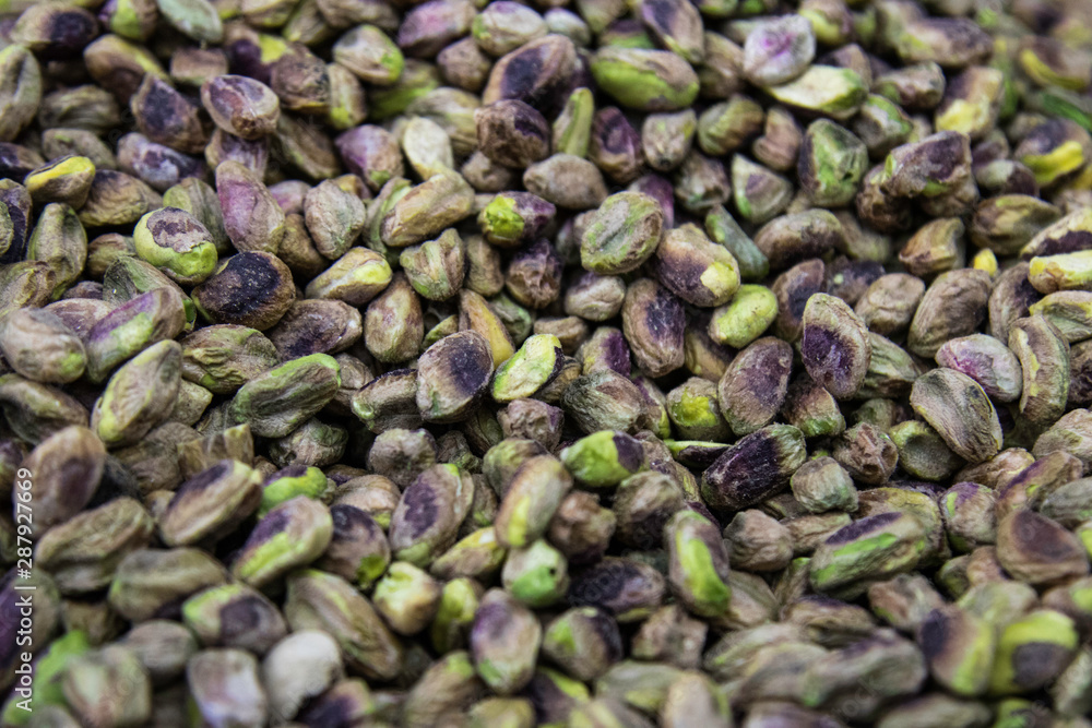 Nutty background of green and purple pistachio nuts Nutty background of green and purple pistachio nuts