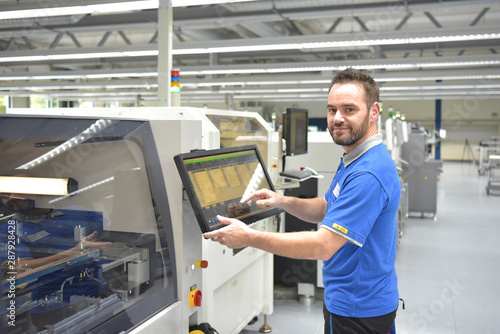 Arbeiter in einer modernen Fabrik bedient Maschine - Portrait Mann am Arbeitsplatz