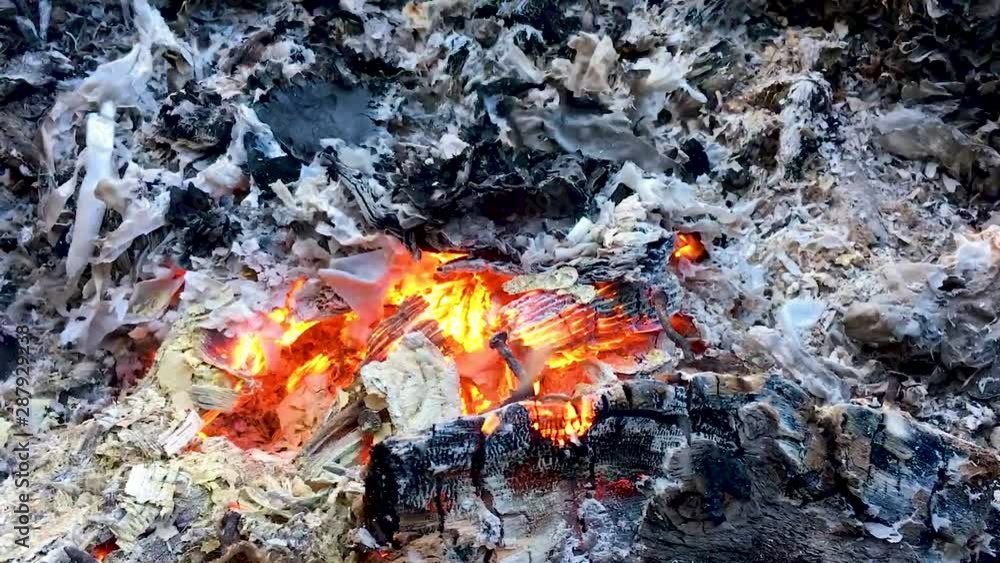 Smoldering red coals in the fire that blows the wind filmed close-up. Ashes from a fire scatter in hand. Fire in slow motion. Smoldering red coals in the fire that blows the wind filmed close-up. Ashes from a fire scatter in hand. Fire in slow motion.