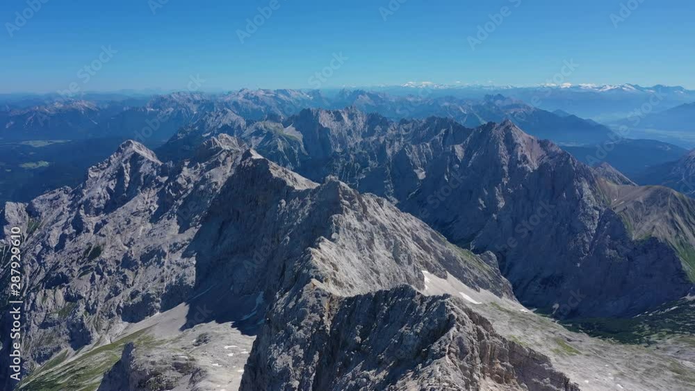 Aerial view of summit of Zugspitze mountain, highest peak of Germany and Wetterstein Mountains during summer - landscape panorama of Alps from above, Germany/Austria border, Europe Aerial view of summit of Zugspitze mountain, highest peak of Germany and Wetterstein Mountains during summer - landscape panorama of Alps from above, Germany/Austria border, Europe