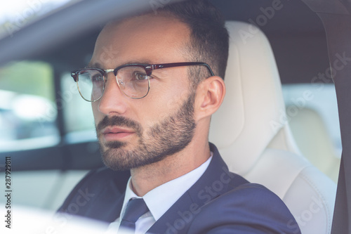 Handsome bearded businessman sitting in white car salon © zinkevych