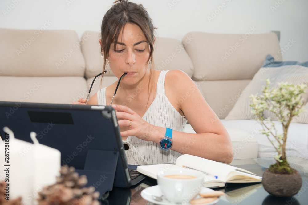 Attractive young businesswoman with white shirt , working from home Attractive young businesswoman with white shirt , working from home