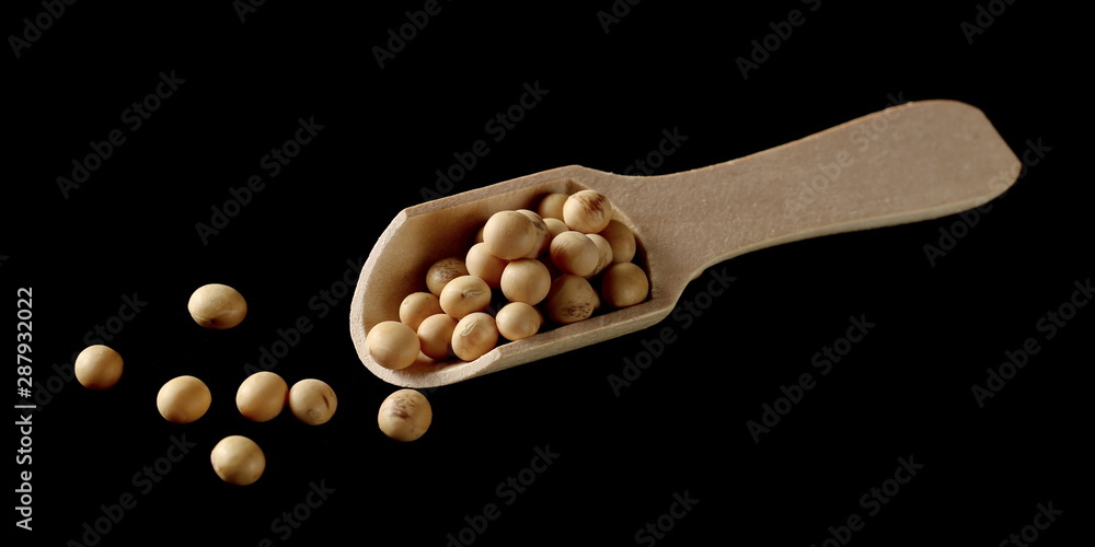 Organic raw soybeans, soy with wooden spoon, isolated on black background Organic raw soybeans, soy with wooden spoon, isolated on black background