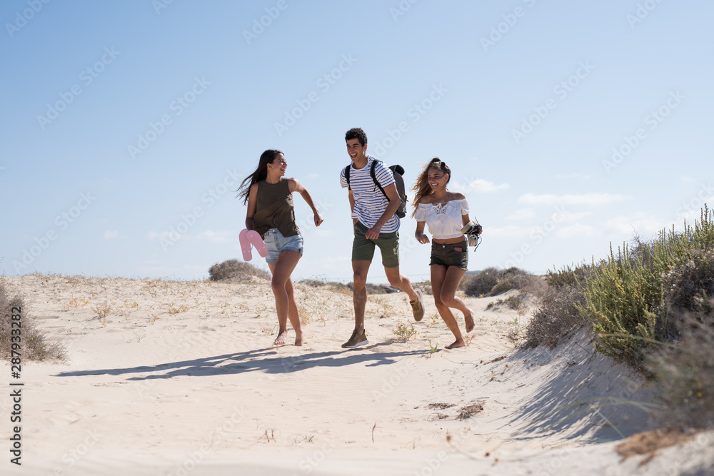Three young people running on the beach Three young people running on the beach