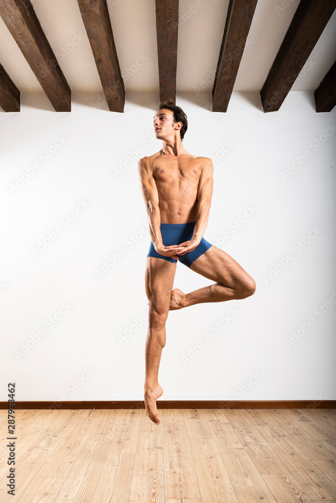 Beautiful male ballett dancer performing indoor