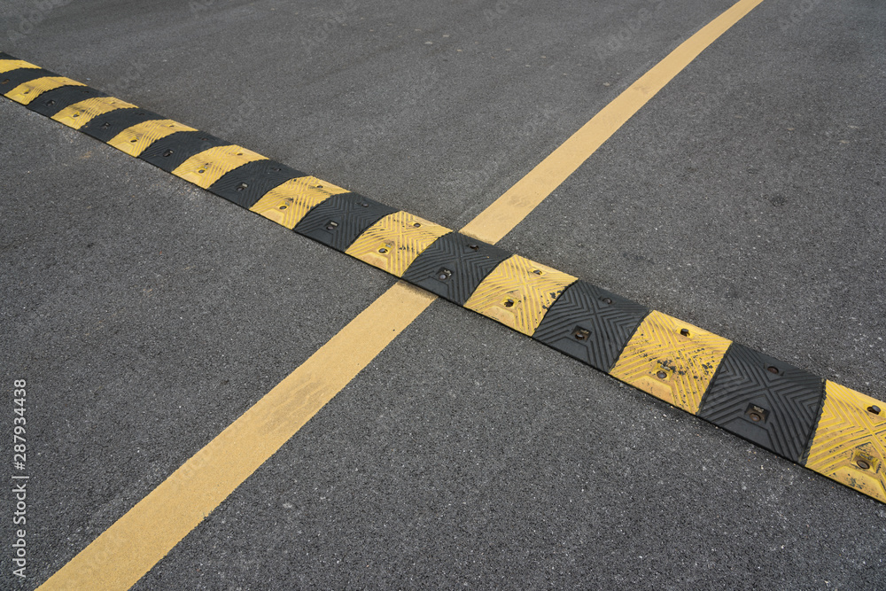 Fototapeta premium Yellow paint line and speed bump line on asphalt road