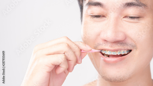 handsome  smile young man is using dental floss