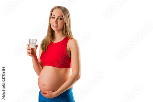beautiful young pregnant woman in sportswear with a glass of water © Alexandr