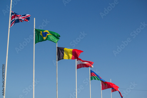 Flags of the world countries blowing in the wind on a background of the blue sky