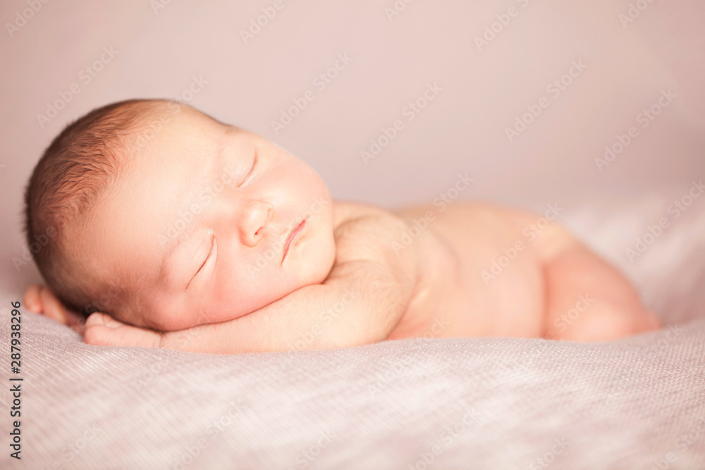 Newborn baby girl sleeping like a baby on a pink beanbag Newborn baby girl sleeping like a baby on a pink beanbag