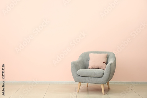 Comfortable armchair near color wall © Pixel-Shot