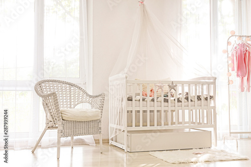 Interior of light modern baby room with crib