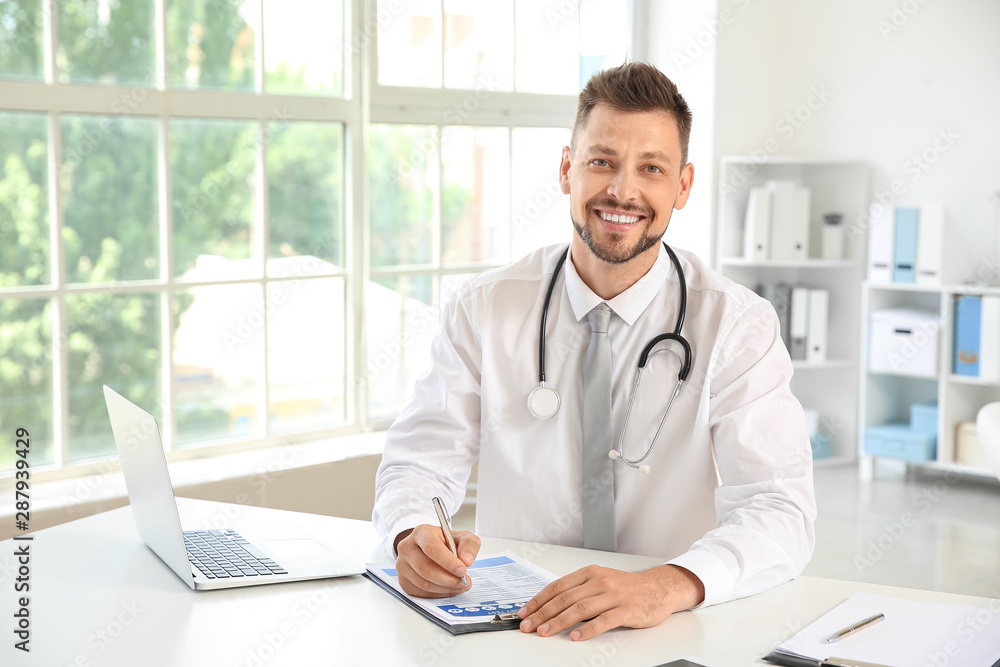 Male doctor working at table in clinic Male doctor working at table in clinic