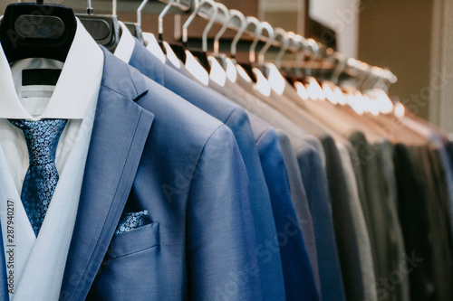 Men suit jackets on hanger in a shop photo