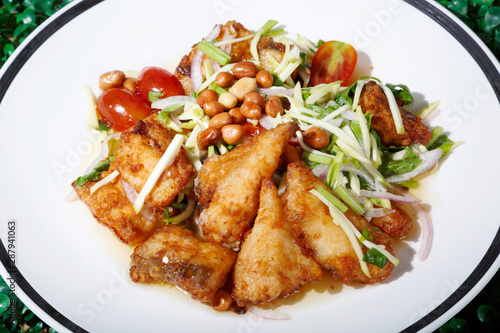 Hot and spicy sour Thai Salads. With  Fried Fish and Chopped Mango. Sea bass.