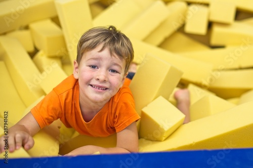 Little boy in yellow gymnastic foam pits