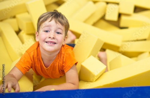 Little boy in yellow gymnastic foam pits