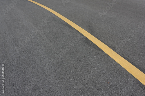 Low angle view of asphalt bend yellow paint line © bqmeng