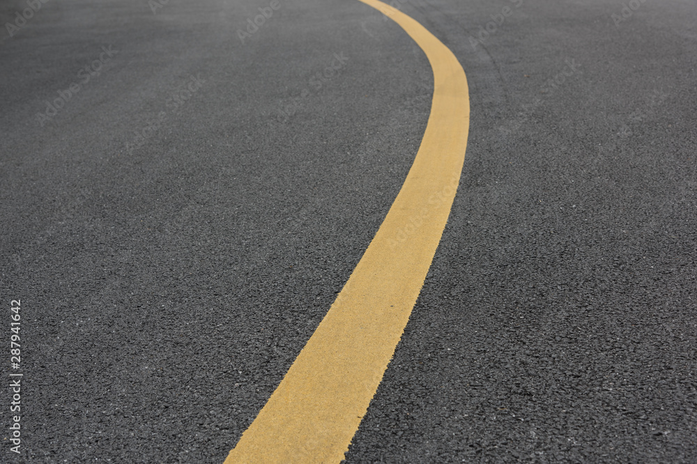 Low angle view of asphalt bend yellow paint line