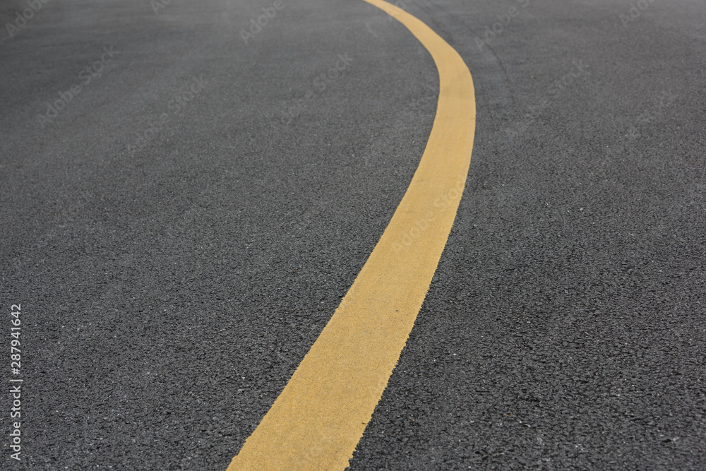 Low angle view of asphalt bend yellow paint line Low angle view of asphalt bend yellow paint line