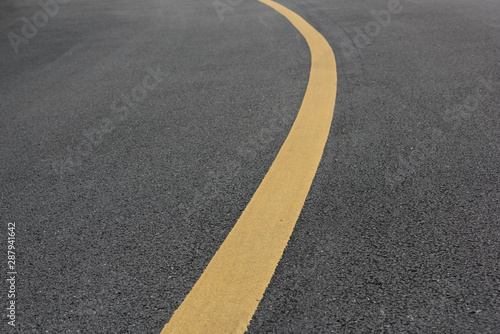 Low angle view of asphalt bend yellow paint line © bqmeng