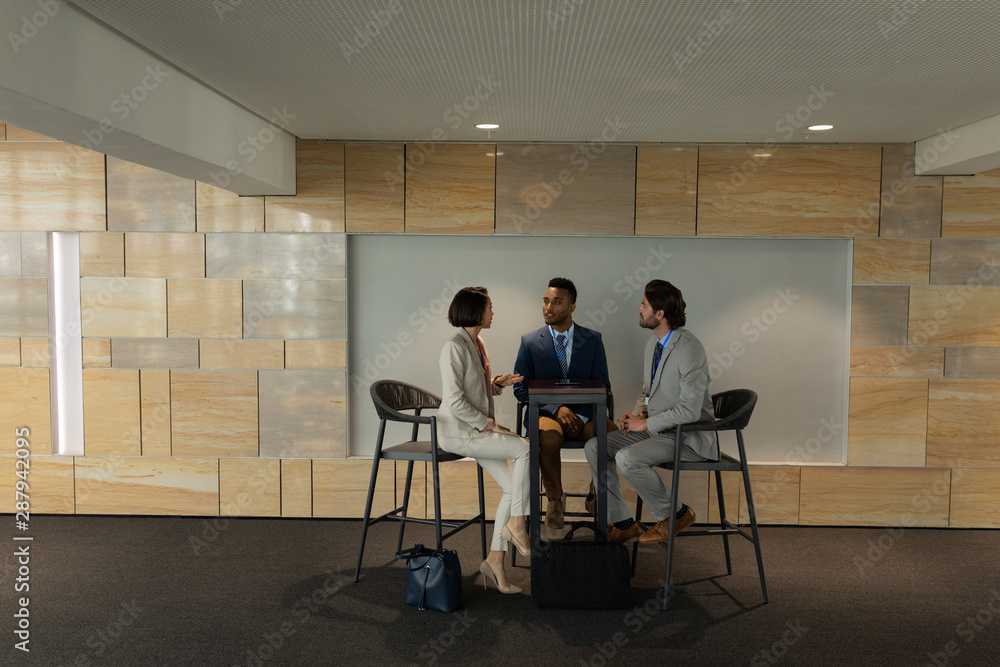Multi-ethnic business people sitting and discussing with each other in meeting room Multi-ethnic business people sitting and discussing with each other in meeting room
