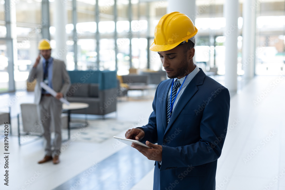 Mixed-race male architect using digital tablet in modern office Mixed-race male architect using digital tablet in modern office