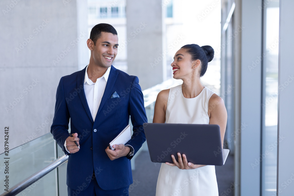 Young mixed-race business people interacting with each other in modern office Young mixed-race business people interacting with each other in modern office