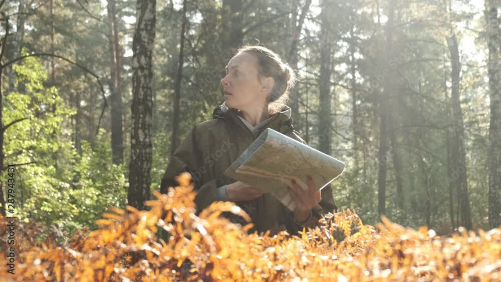 Woman lost in the forest, looking at old map, thinking, nature background, concept: search for yourself. Woman with map in forest. Woman lost in the forest, looking at old map, thinking, nature background, concept: search for yourself. Woman with map in forest.