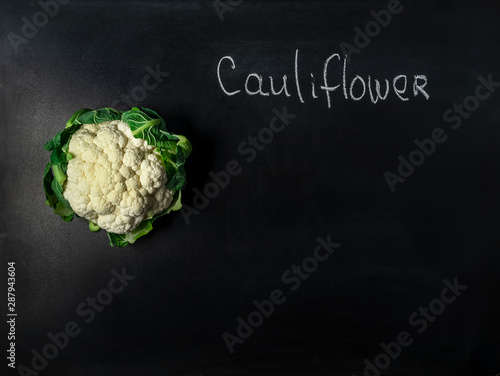 Head of cauliflower on black board with incription photo