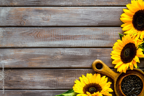 Field flowers design with sunflowers and seeds frame on wooden background top view space for text