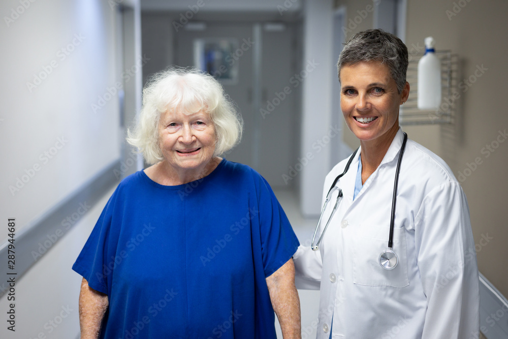 Mature female doctor and senior female patient standing in hospital clinic Mature female doctor and senior female patient standing in hospital clinic