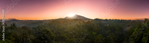 Mount Agung volcano during a dramatic sunrise surrounded by rainforest panoramic  Bali  Indonesia 
