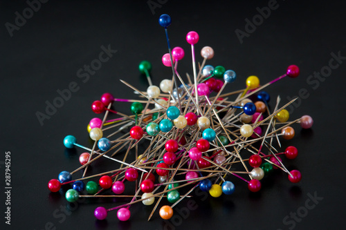 multicolored pins on black background - top