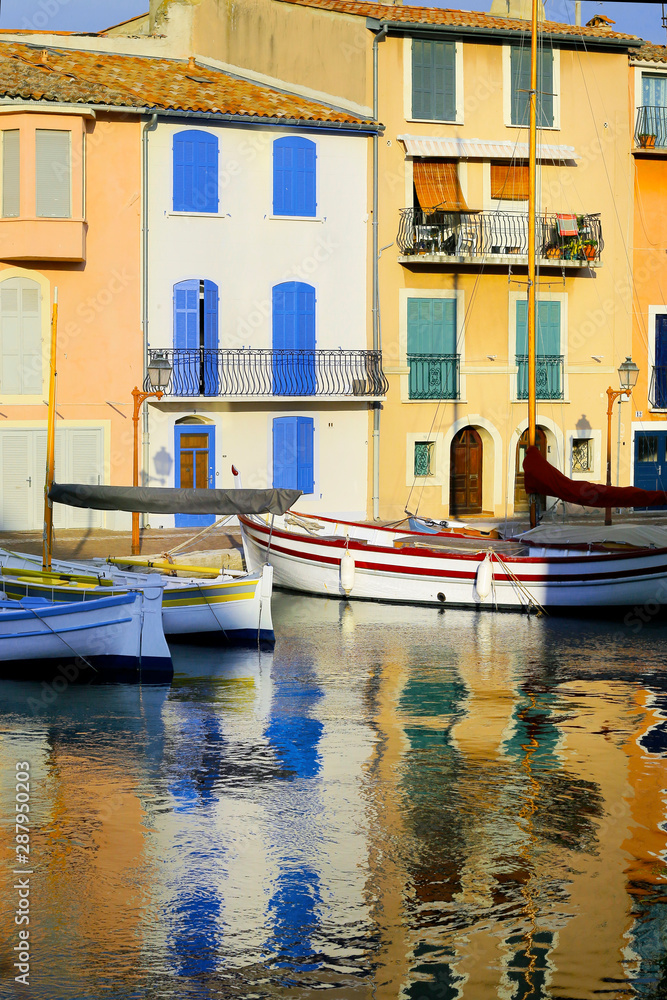  facade of mediterranean building with colorful shutter with river and boat