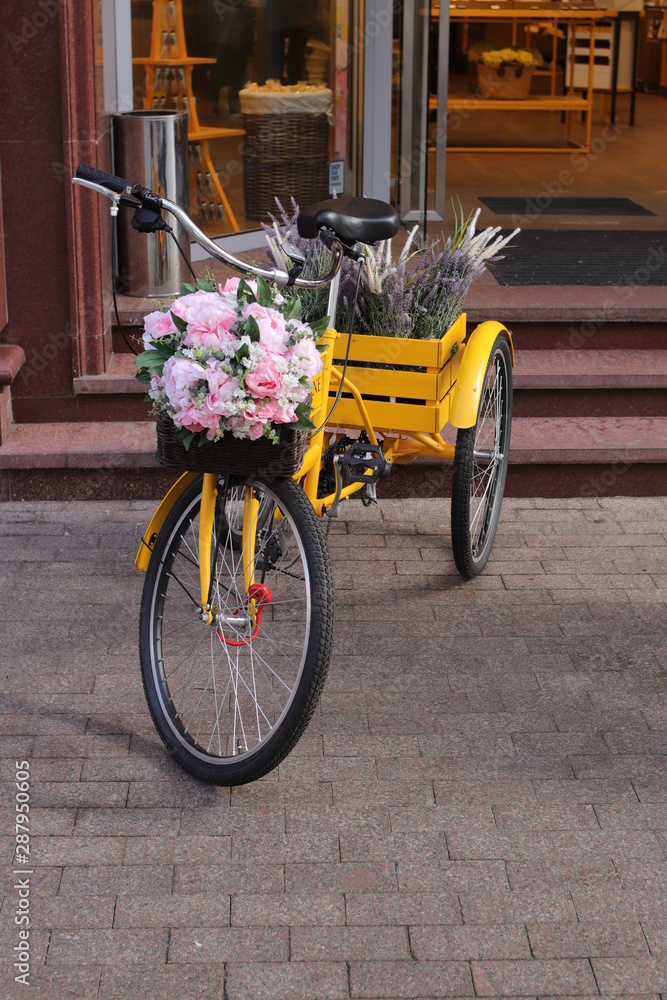 vintage yellow bicycle with flowers on the street