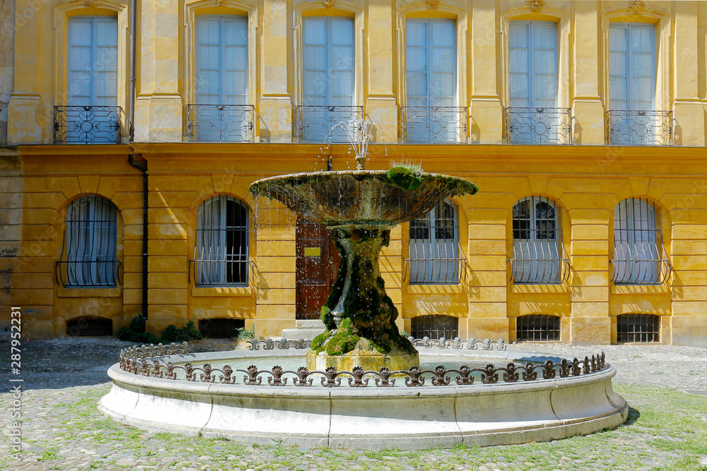 stone fountain in mediterranean courtyard with historical building  