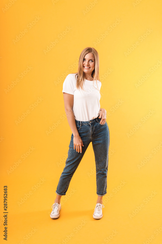 Full length image of caucasian blond woman wearing casual t-shirt smiling at camera Full length image of caucasian blond woman wearing casual t-shirt smiling at camera