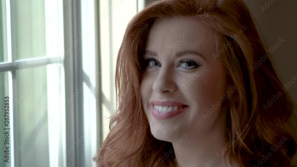 Beautiful red headed woman smiling and looking at camera Beautiful red headed woman smiling and looking at camera
