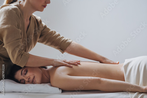 Pretty Caucasian woman enjoying back massage at spa salon. photo
