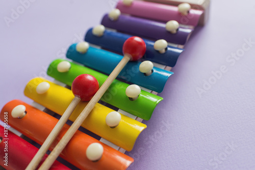 A toy wooden colorful xylophone on purple background with copy space. Children s toy and musical instrument. Music and childhood concept.