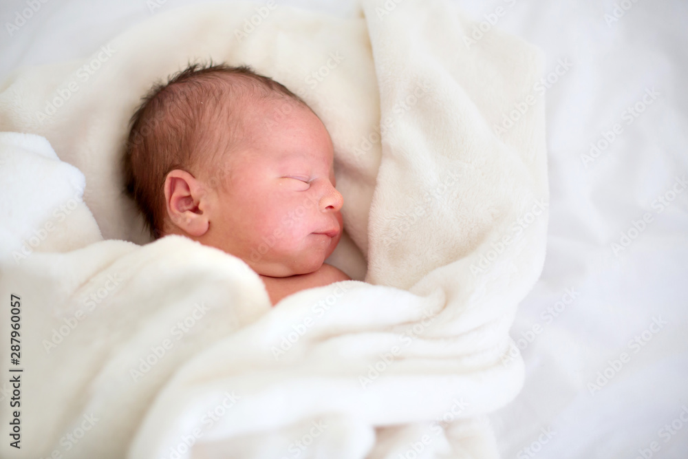 Newborn baby laying in crib in prenatal hospital Newborn baby laying in crib in prenatal hospital