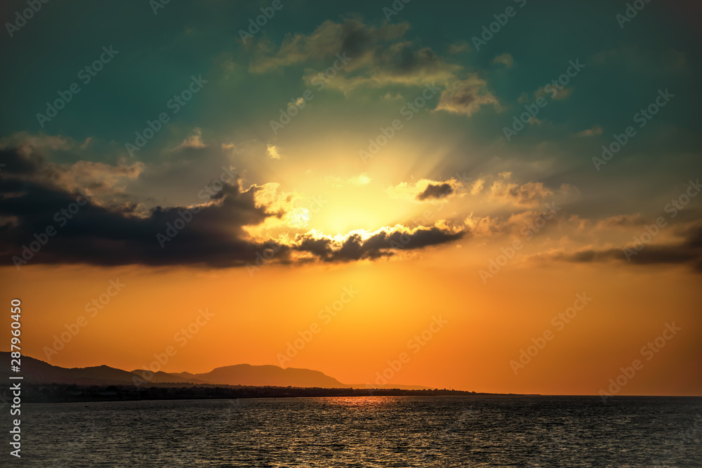 The sea coast at sunset in North Cyprus. Background of sky and the sun setting over the horizon. Beautiful landscape