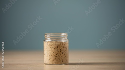 Starter yeast rising in a glass jar