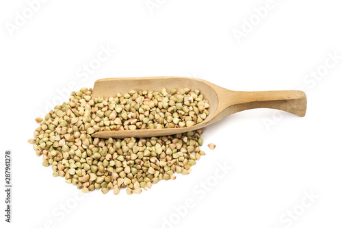 Green buckwheat in a pile and on a wooden spoon or scoop seen obliquely from above and isolated on white background