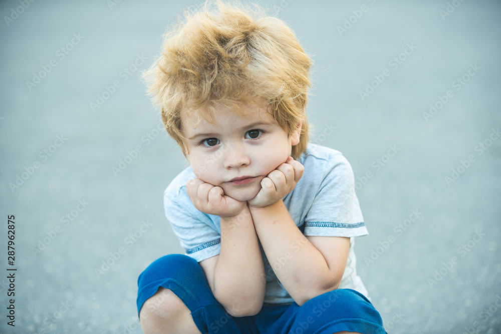 Pensive child. Calm boy. The child is resting on the street. Beautiful portrait. Pensive child. Calm boy. The child is resting on the street. Beautiful portrait.