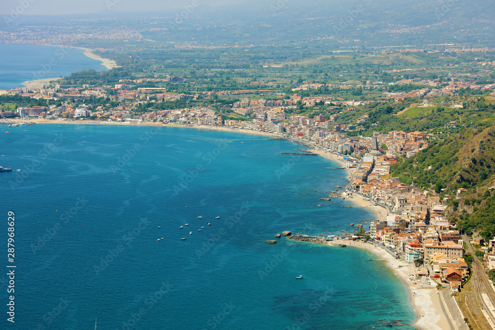 Aerial view of Eastern Sicily coast with blue sea. Beautiful Italy coastline.