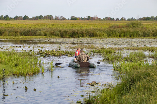 Fishermen in a boat swim in a pond