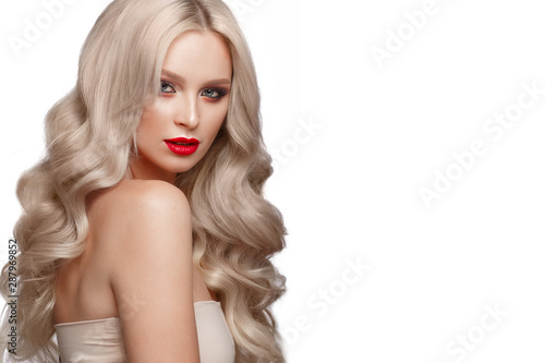 Beautiful blonde in a Hollywood manner with curls, natural makeup and red lips. Beauty face and hair.